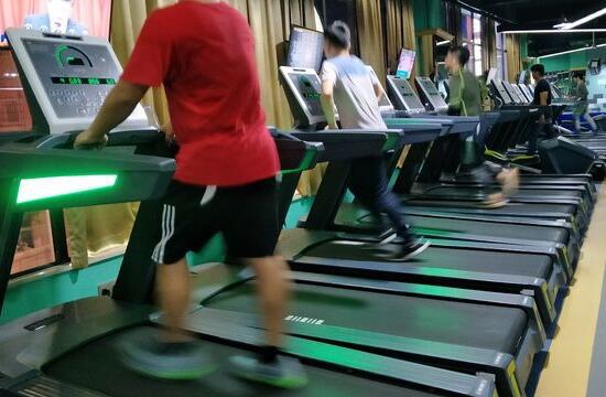 手抓扶手在跑步机上跑步